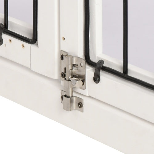 Close-up of a metal latch and black bar on the white frame of a crate door.
