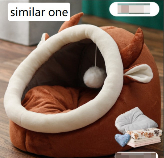 Brown rounded cat bed with a cream oval entrance, brown cushion, and hanging ball.