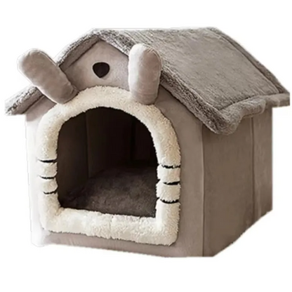 Gray house-shaped pet bed with a pale-trimmed arched entrance, shown empty against a light background.