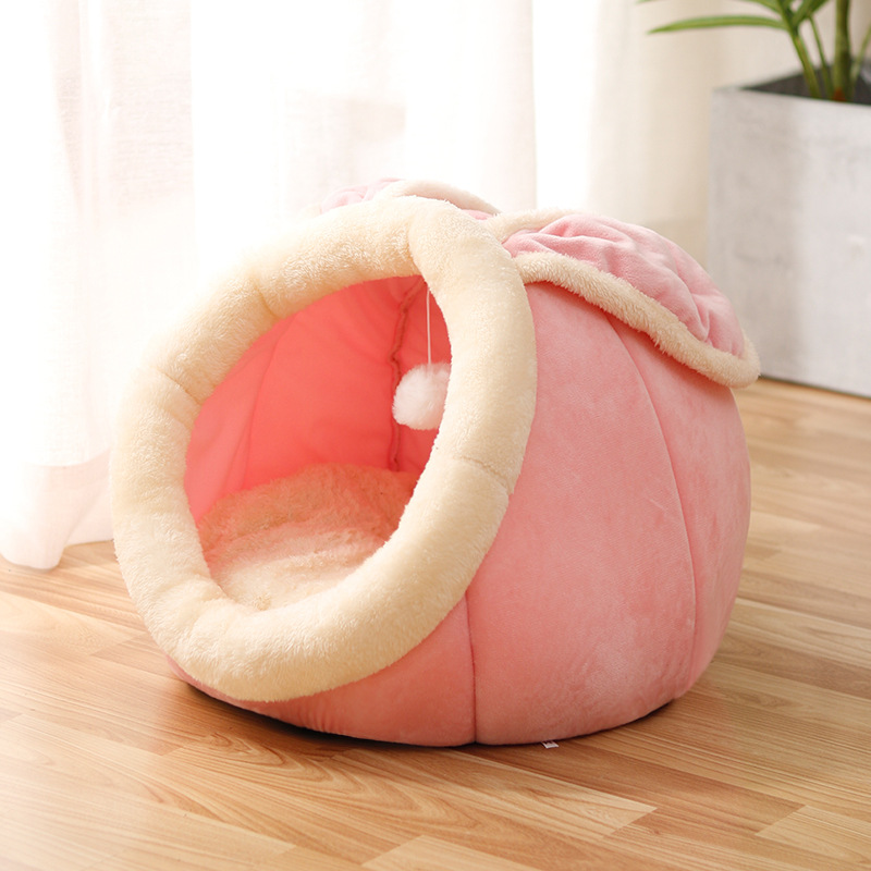 Pink rounded cat bed with a cream-trimmed oval entrance and bright pink interior.