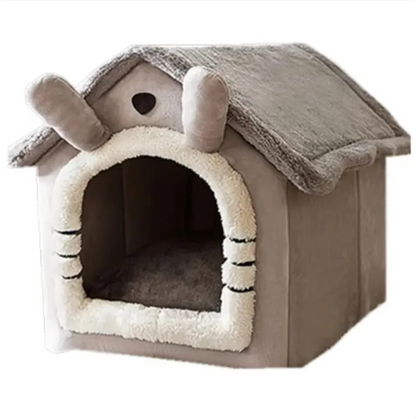 Gray house-shaped pet bed with a pale-trimmed arched entrance, shown empty against a light background.