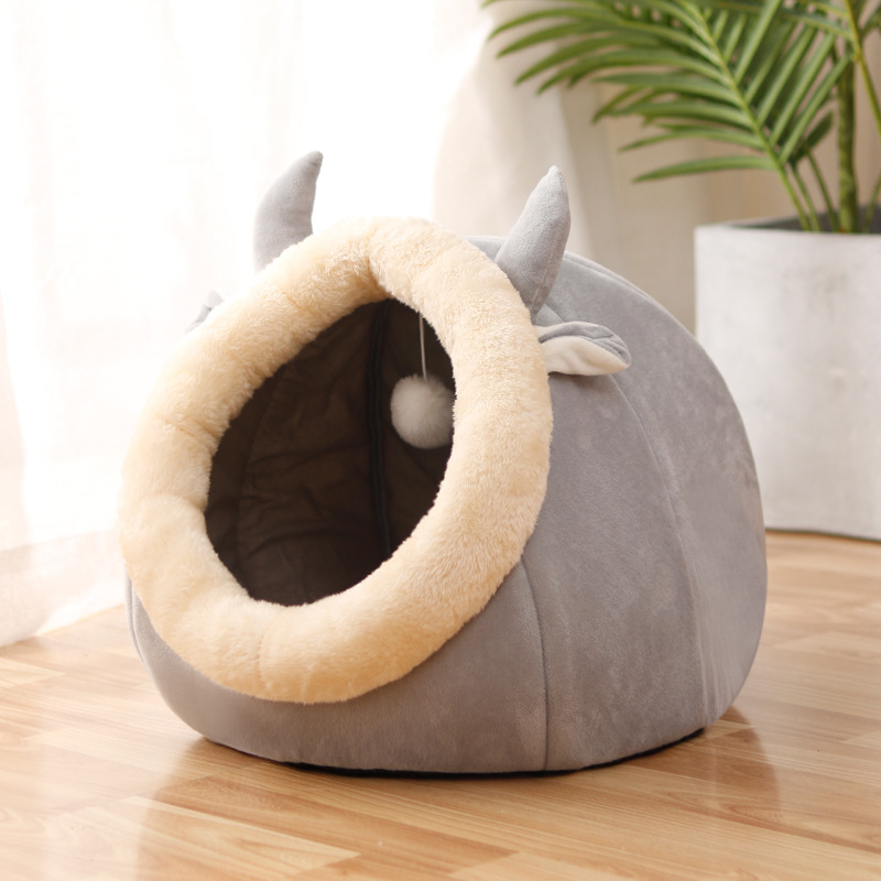Gray rounded cat bed with a cream oval entrance and pointed ears.